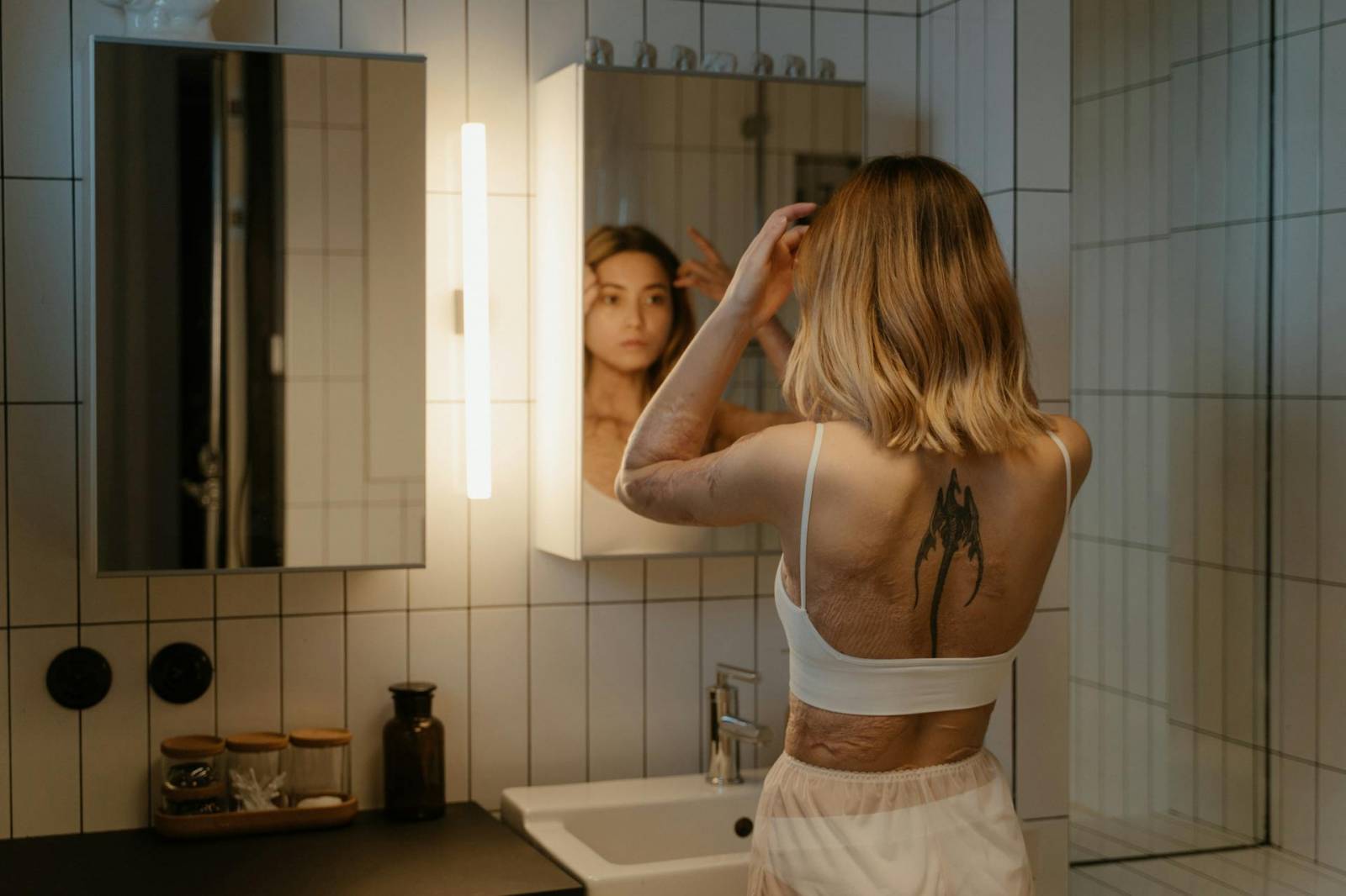 Femme avec des cicatrices qui se regarde dans le miroir